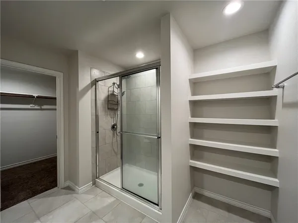 a bathroom with a shower and a glass door