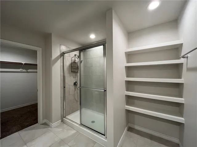 a bathroom with a shower and a glass door