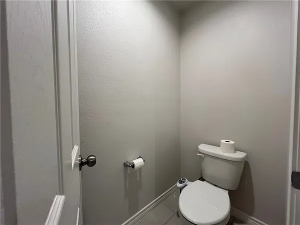 a white toilet sitting next to a white cabinet