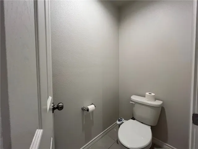 a white toilet sitting next to a white cabinet