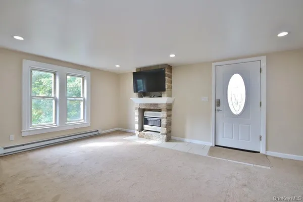 an empty room with windows and fireplace