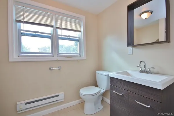 a bathroom with a toilet a sink a vanity and mirror