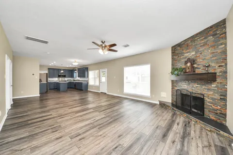 a view of empty room with wooden floor and fireplace