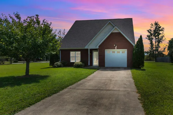 a front view of a house with a garden and yard