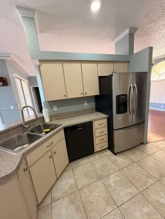 a kitchen with stainless steel appliances a sink a stove a microwave a counter top space and cabinets