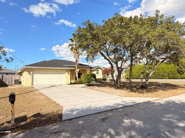 a white house that has a tree in front of it