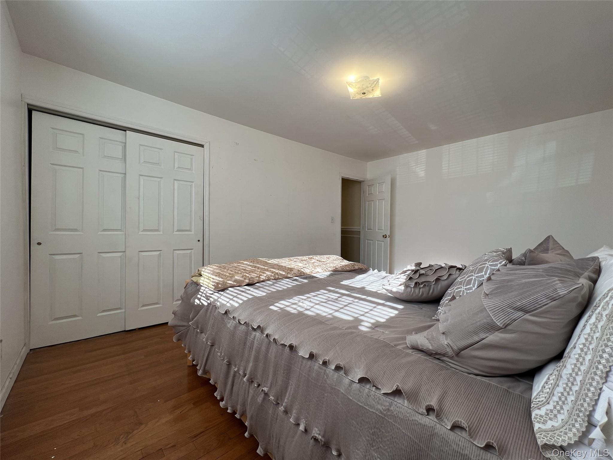 86-16 60th Avenue, Unit 2D Queens, NY 11373 - Photo 17 of 30 a bedroom with a bed and wooden floor