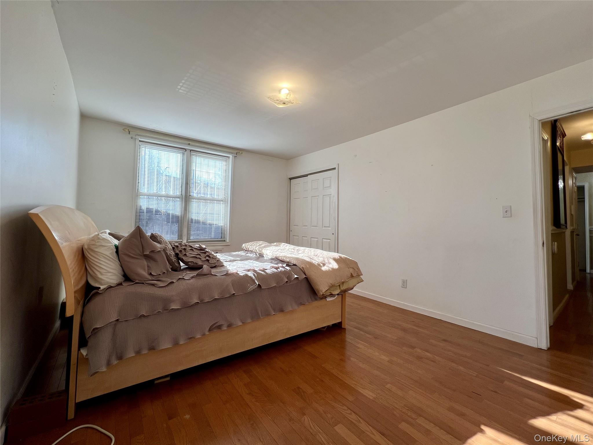 86-16 60th Avenue, Unit 2D Queens, NY 11373 - Photo 18 of 30 a bedroom with a bed and wooden floor