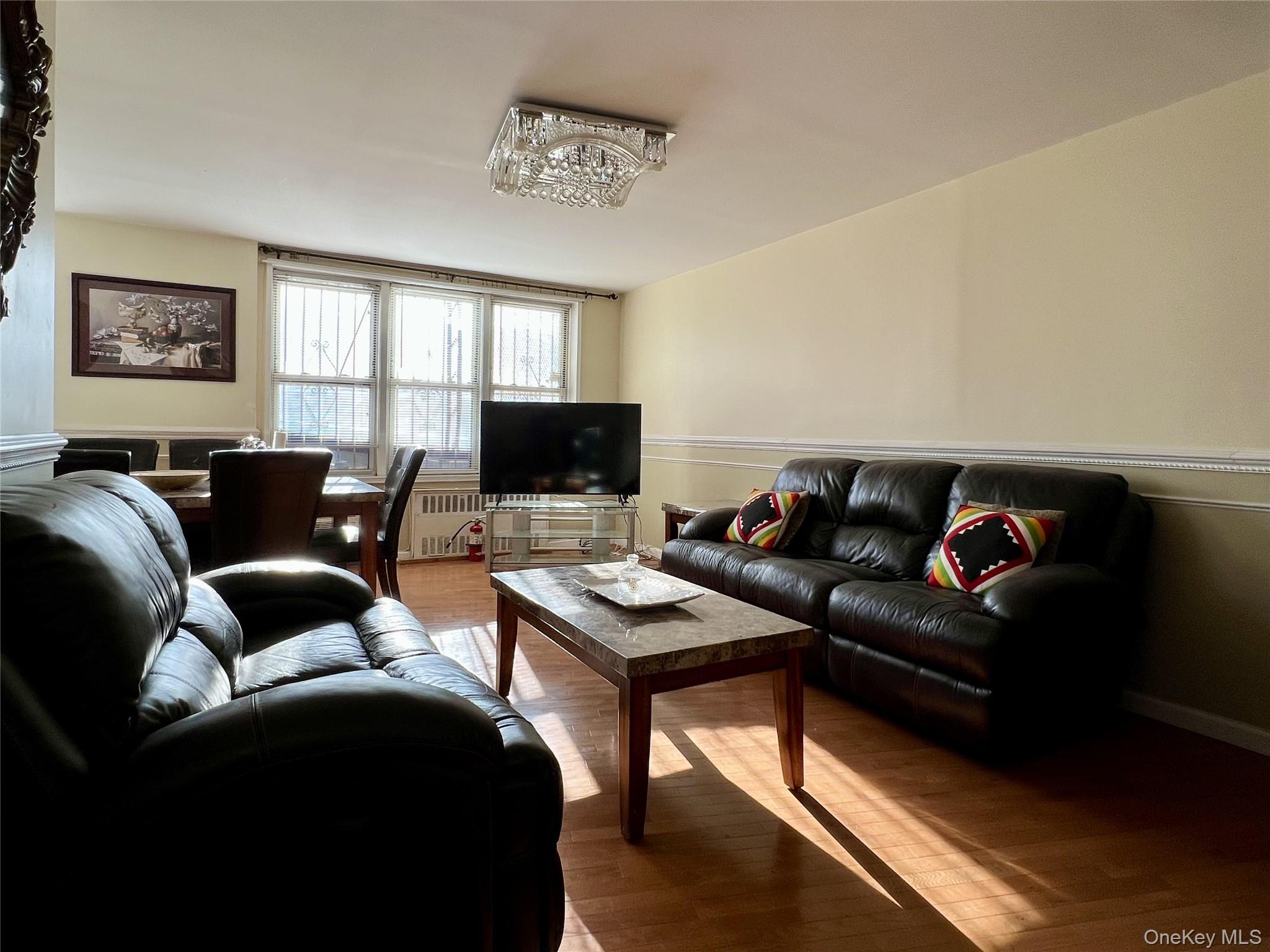 86-16 60th Avenue, Unit 2D Queens, NY 11373 - Photo 6 of 30 a living room with furniture and a flat screen tv