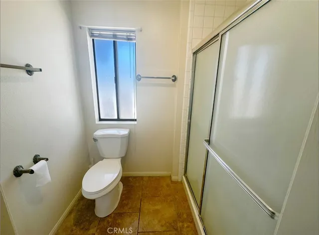 a bathroom with a toilet and a shower