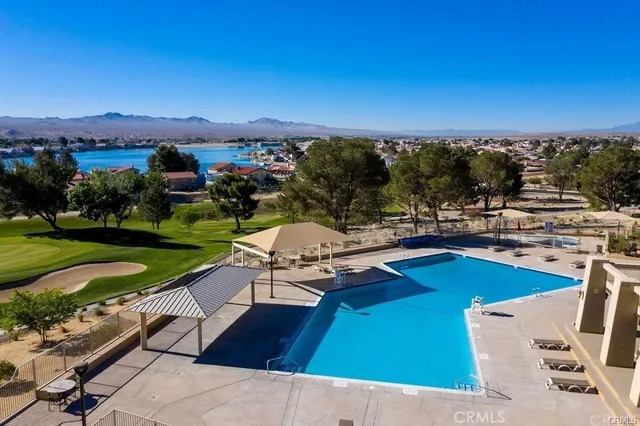 a view of a swimming pool with lounge chair and lounge chairs