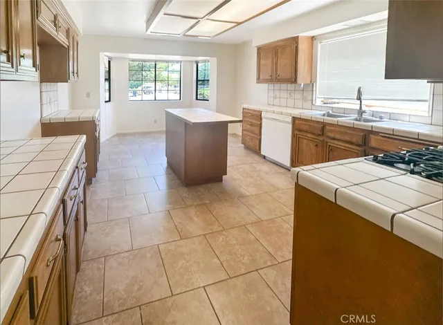 a kitchen with a sink a stove cabinets and counter space