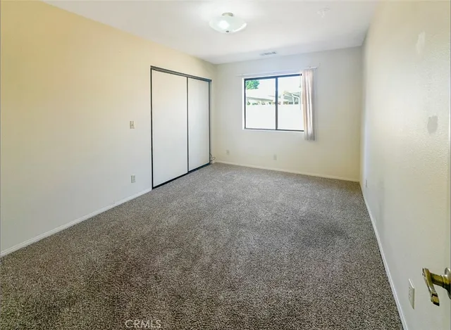 an empty room with windows and closet