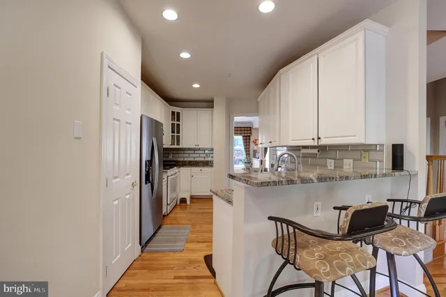 a kitchen with stainless steel appliances granite countertop a refrigerator and a stove top oven
