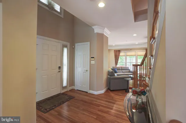 a view of a hallway to room with wooden floor and furniture