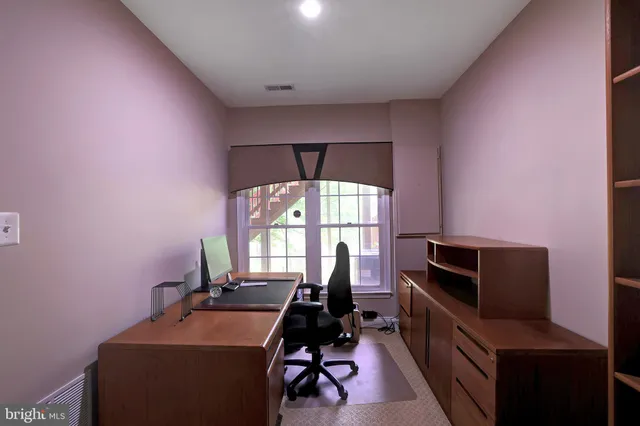 a room with furniture a air conditioner vent and a window