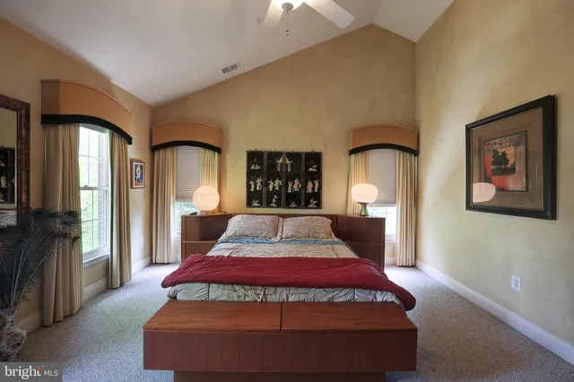 a bed sitting in a spacious bedroom next to a window