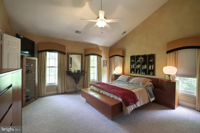 a spacious bedroom with a large bed and a chandelier