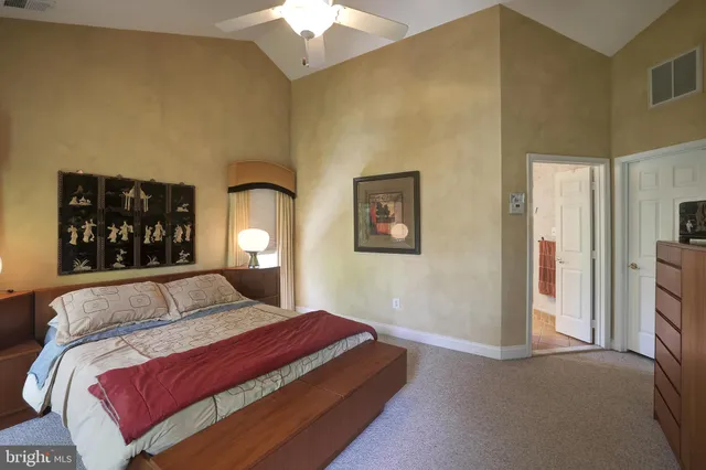 a bedroom with a large bed and a chandelier