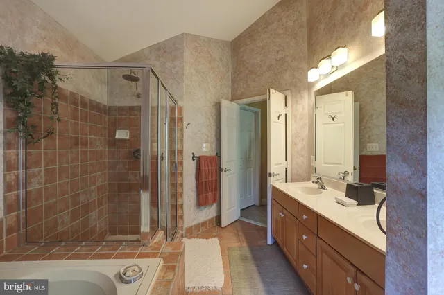 a bathroom with a double vanity sink mirror and shower