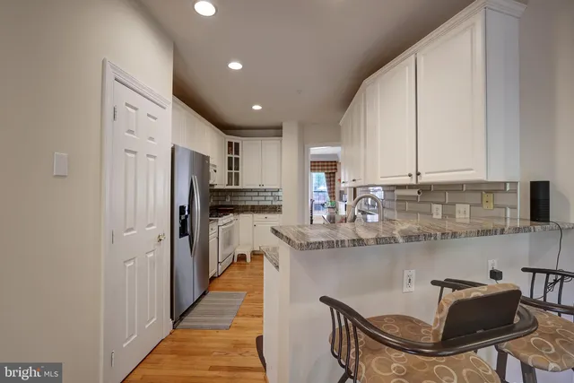 a kitchen with stainless steel appliances granite countertop a sink refrigerator and cabinets