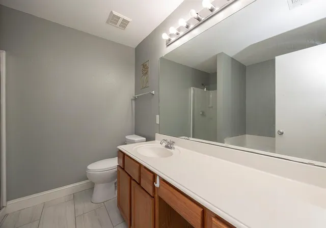 a bathroom with a sink a toilet and a mirror