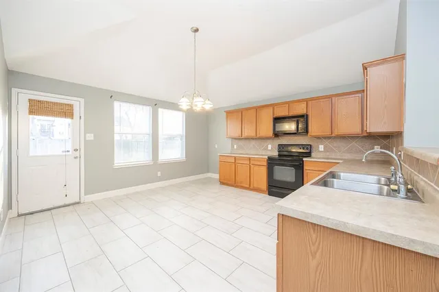 a kitchen with granite countertop a sink stainless steel appliances and cabinets