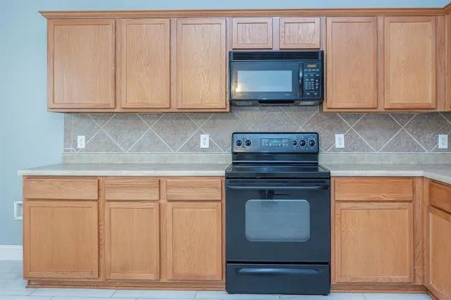 a kitchen with granite countertop white cabinets and stainless steel appliances