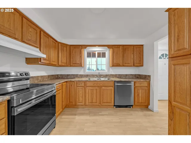 a kitchen with stainless steel appliances granite countertop a stove a sink and a microwave