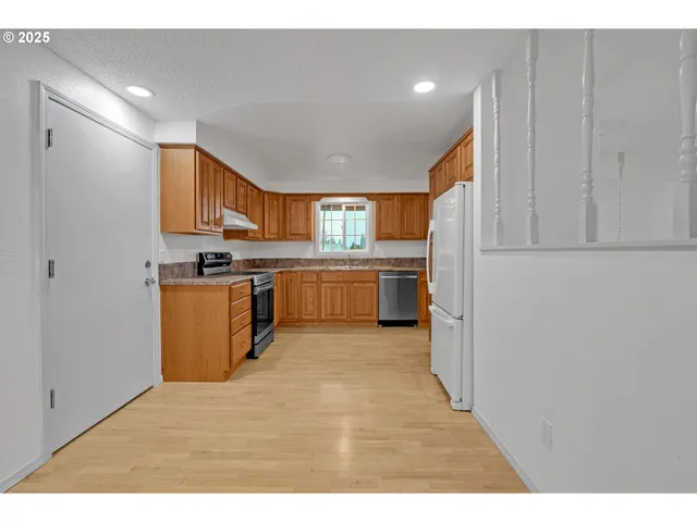 a kitchen with stainless steel appliances granite countertop a stove a sink and a refrigerator