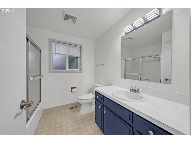 a bathroom with a sink vanity granite and toilet