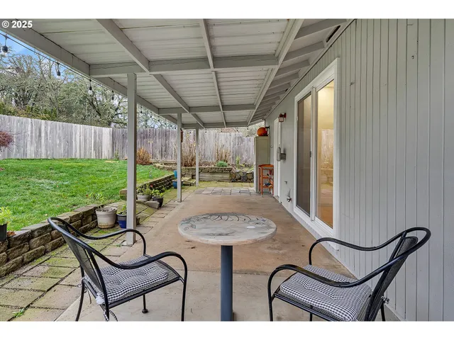 a view of a chairs and table in patio with wooden fence