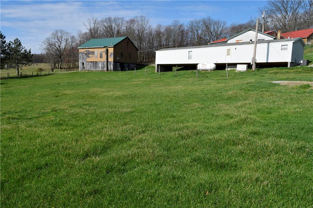 254 Piper Gross Road Latrobe, PA 15650 - Photo 5 of 42 a view of a back yard with an tree and wooden fence