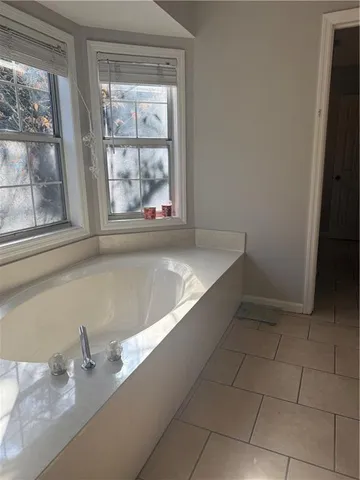 a bath tub sitting in a bathroom next to a window