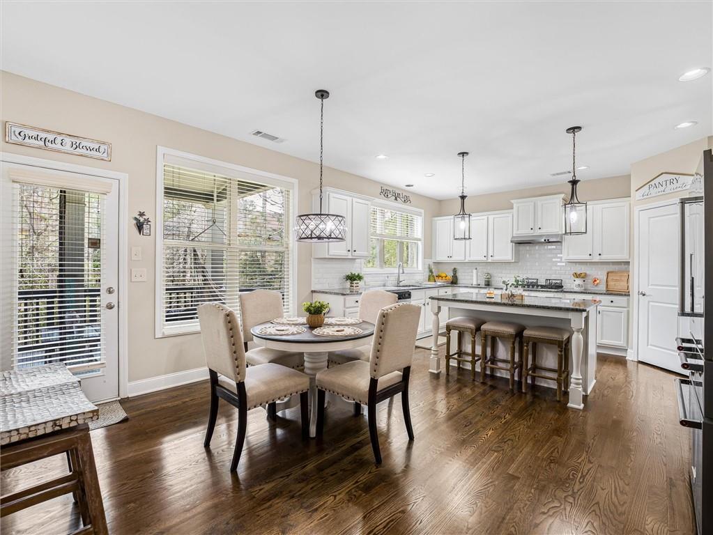 2297 Roberts View Trail Buford, GA 30519 - Photo 14 of 64 a kitchen with a dining table chairs and refrigerator