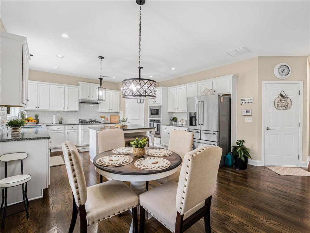2297 Roberts View Trail Buford, GA 30519 - Photo 15 of 64 a view of a dining room and livingroom with furniture wooden floor a chandelier