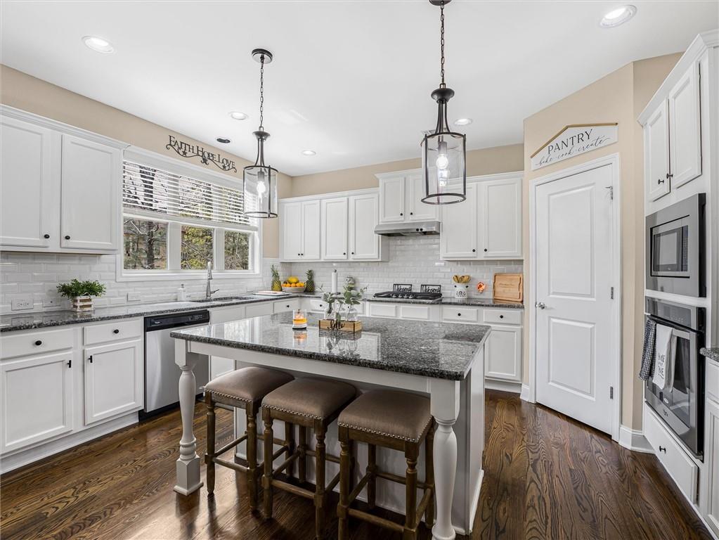 2297 Roberts View Trail Buford, GA 30519 - Photo 17 of 64 a kitchen with granite countertop white cabinets and stainless steel appliances