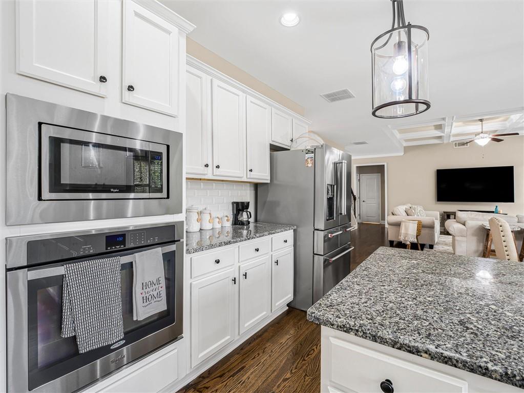 2297 Roberts View Trail Buford, GA 30519 - Photo 21 of 64 a kitchen with stainless steel appliances granite countertop a sink stove microwave and refrigerator