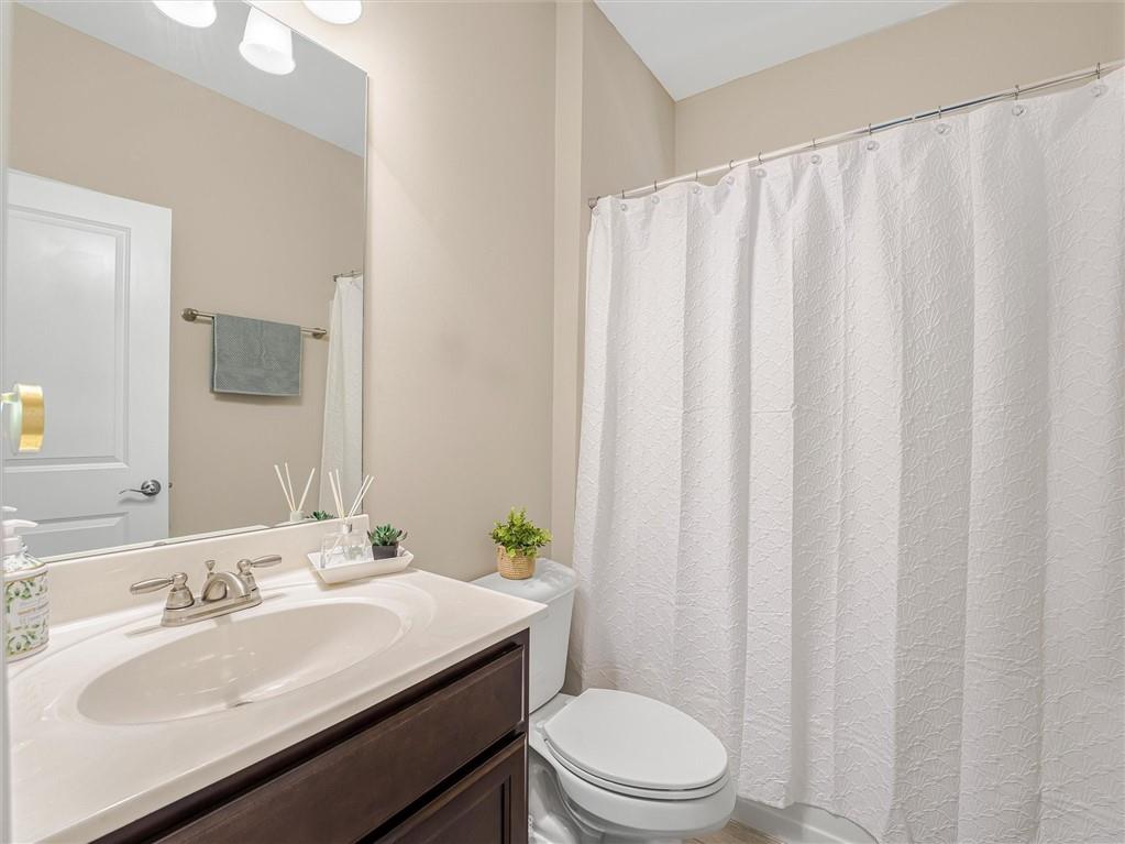 2297 Roberts View Trail Buford, GA 30519 - Photo 26 of 64 a bathroom with a sink a toilet and shower curtain