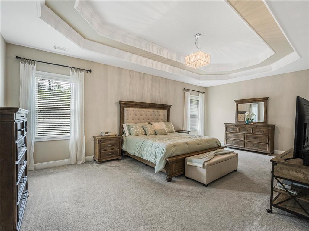 2297 Roberts View Trail Buford, GA 30519 - Photo 30 of 64 a spacious bedroom with a bed and a tv