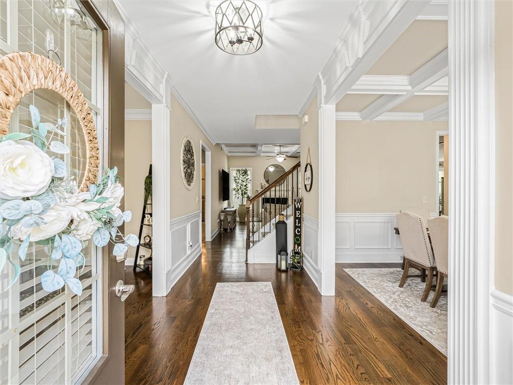 2297 Roberts View Trail Buford, GA 30519 - Photo 4 of 64 a hallway with a dining table wooden floor and a large window