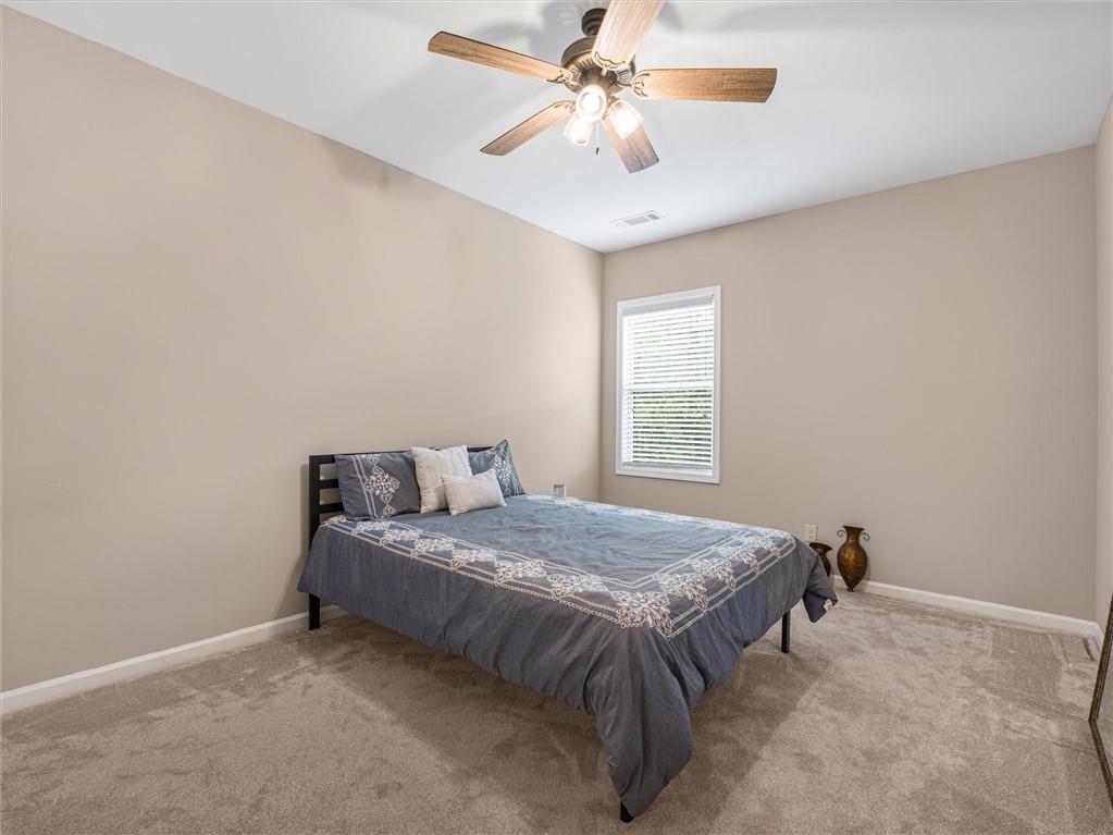 2297 Roberts View Trail Buford, GA 30519 - Photo 41 of 64 a bedroom with a bed and a chandelier