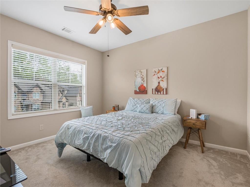 2297 Roberts View Trail Buford, GA 30519 - Photo 45 of 64 a bedroom with a bed and a chandelier