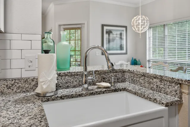 a bathroom with a granite countertop sink a mirror and window