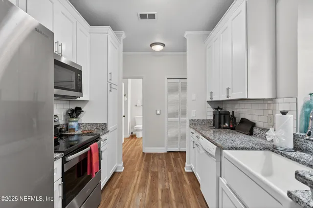 a kitchen with granite countertop a sink and a stove top oven