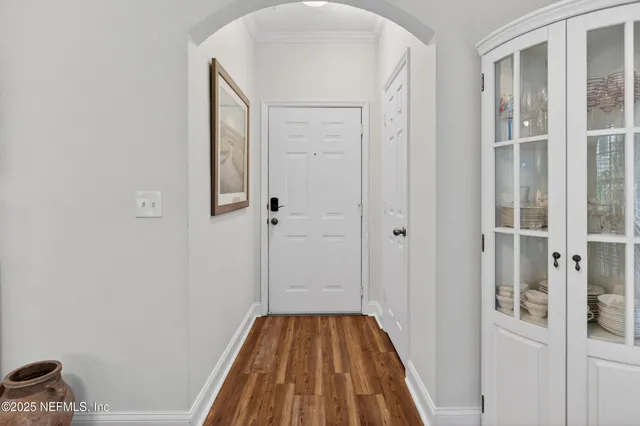 a view of a hallway with wooden floor and closet