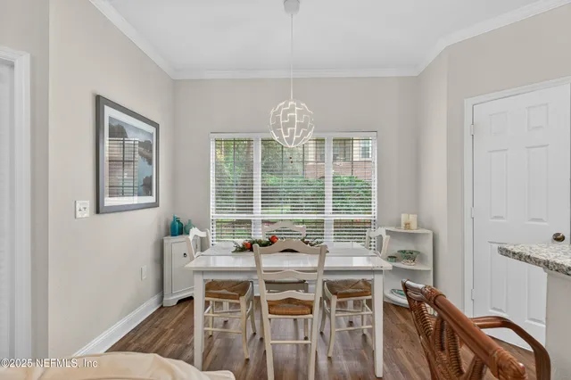 a view of a dining room with furniture a chandelier and wooden floor