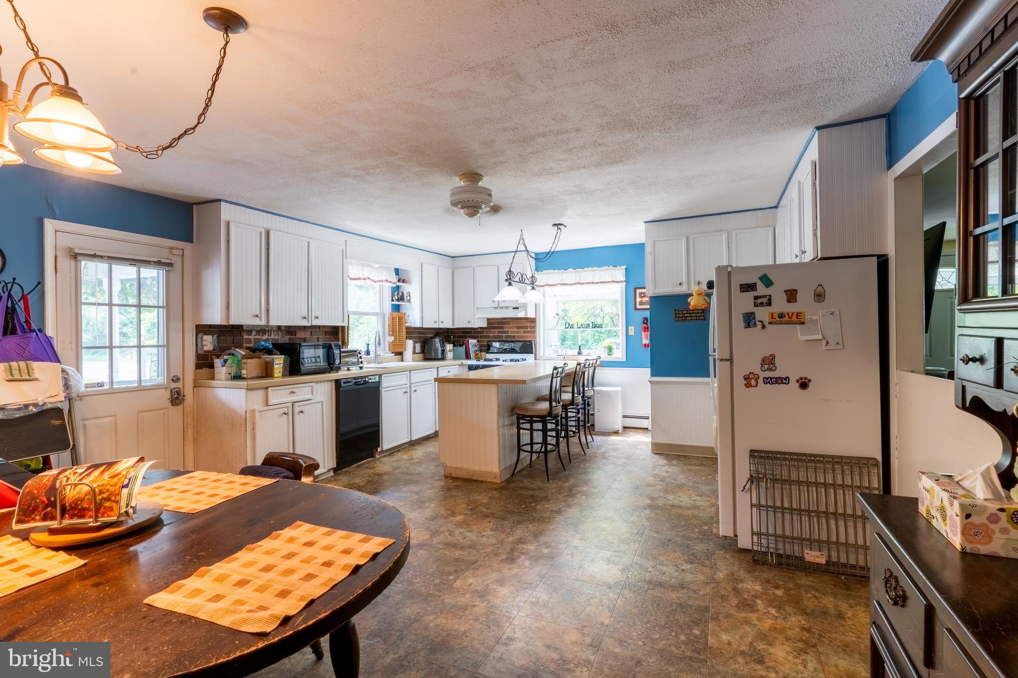 713 Monmouth Road Chesterfield, NJ 08515 - Photo 15 of 25 a kitchen with a table chairs refrigerator and cabinets