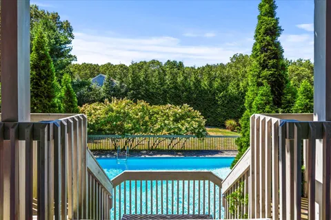 a view of a yard with plants and wooden fence
