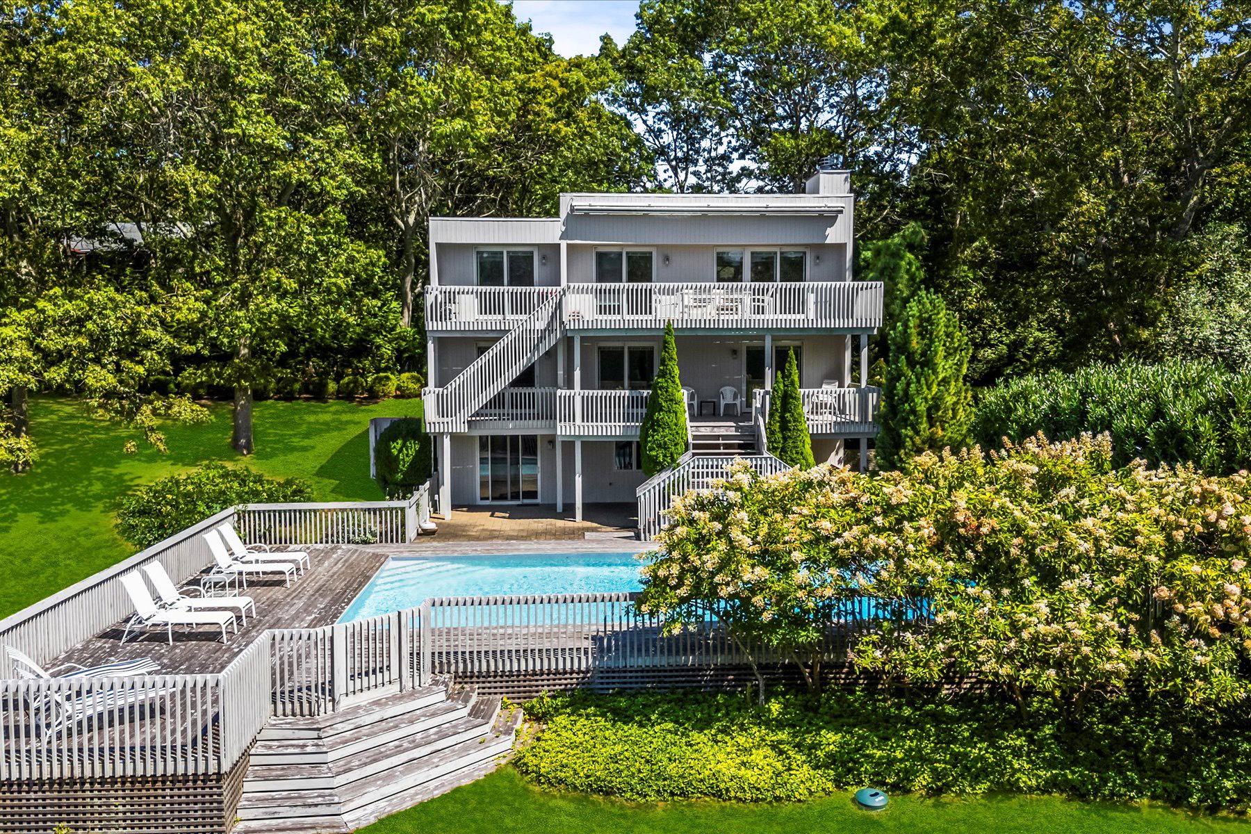 11 Deer Trail Road Southampton, NY 11968 - Photo 4 of 24 a front view of a house with a yard table and chairs